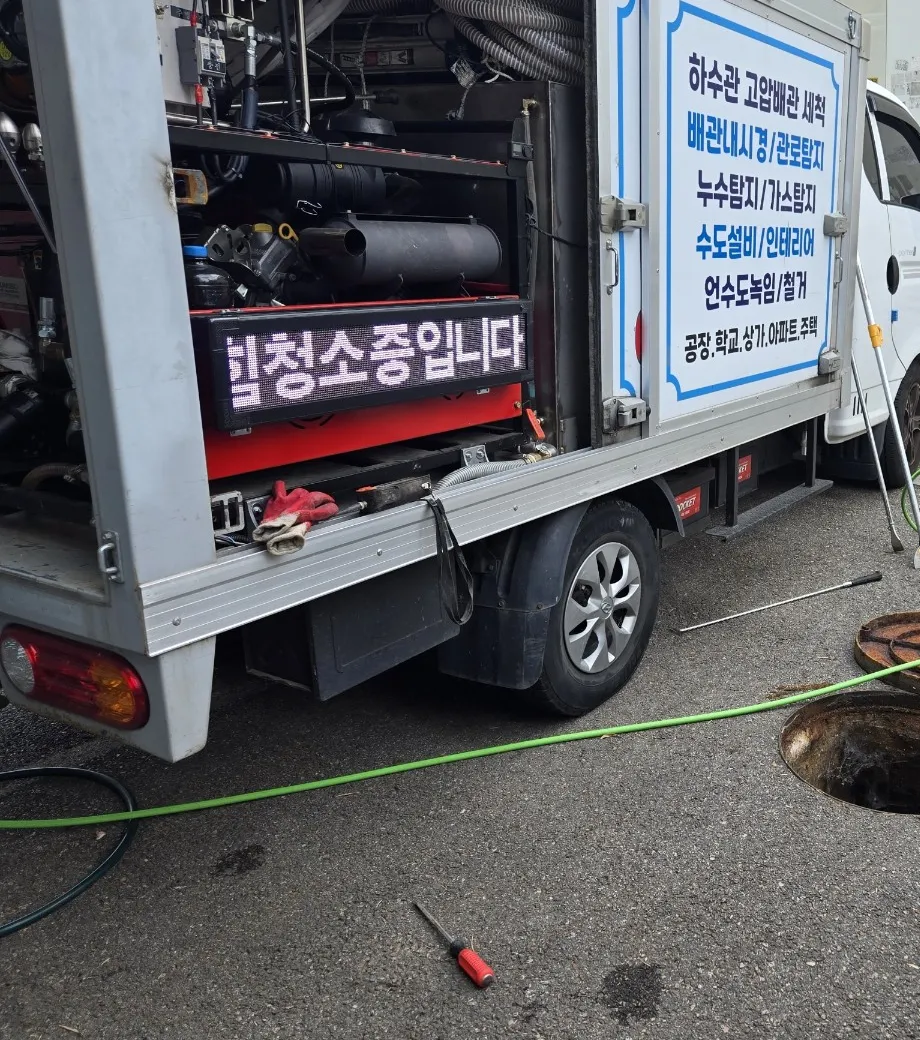 전문 세척 장비를 실은 작업 차량 옆에서 맨홀 고압세척을 진행하는 현장